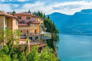 a town on the side of a mountain with a body of water at Casa Claudia Pieve centro storico in Tremosine Sul Garda