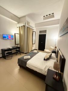 a bedroom with a large bed and a desk at Hotel Plebiscito Aparthotel in Naples