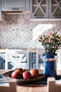 a table with a plate of apples and a vase with flowers at Domek Luna Wilcza Zagroda in Kudowa-Zdrój