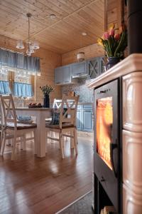 a kitchen and dining room with a table and an oven at Domek Luna Wilcza Zagroda in Kudowa-Zdrój
