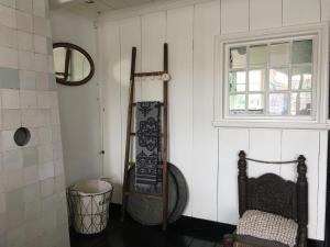 a room with white walls and a window and a chair at De Kleine Prins Enkhuizen in Enkhuizen +1 photo