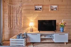 a living room with a television on a wooden wall at Domek Luna Wilcza Zagroda in Kudowa-Zdrój +19 photos