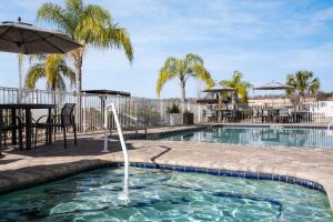 a swimming pool with an umbrella and a fountain at Holiday Inn Express & Suites Trinity by IHG in Trinity