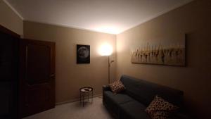 a living room with a couch and a lamp at A casa di Gina in Airasca