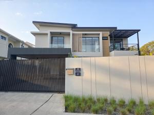 a white fence in front of a house at AURA STAY-Luxury Private Pool Villa walk to Kad Farang in Chiang Mai