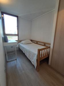 a bedroom with a bed and a desk and a window at Plaza ñuñoa in Santiago +4 photos