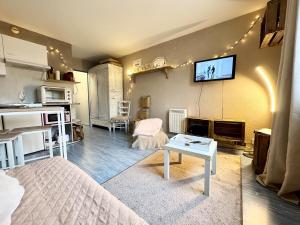 a living room with a bed and a tv on the wall at Vacances à la mer - studio in Calais