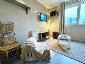 a living room with a tv on the wall at Vacances à la mer - studio in Calais