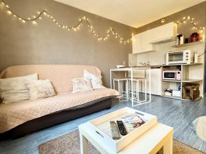 a living room with a couch and a table at Vacances à la mer - studio in Calais