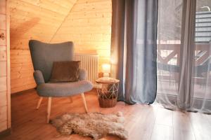 a chair and a rug in a room with a window at Domek Luna Wilcza Zagroda in Kudowa-Zdrój