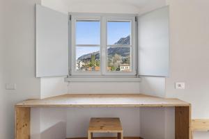 a bench in a room with a window at Foresteria Monastero B&B in Mandello del Lario