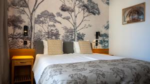 a bedroom with a bed and a wall with trees at Vänerport Stadshotell i Mariestad in Mariestad +275 photos