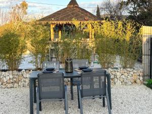 a black table with two chairs and a gazebo at L échappée belle in Vallon-Pont-dʼArc