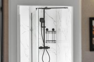 a shower with a shower head and a shower curtain at Birdies Nest in Carnoustie +10 photos
