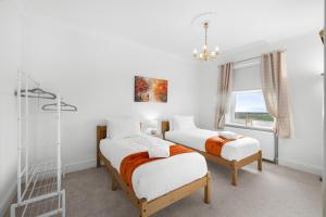 two beds in a room with a window at Birdies Nest in Carnoustie