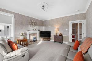 a living room with a couch and a television at Birdies Nest in Carnoustie