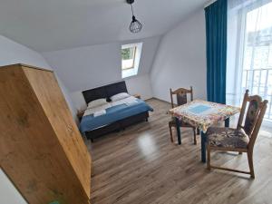 a bedroom with a bed and a table and a chair at Agroturystyka Julinka in Olszyny