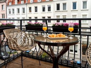 a table with a plate of food and two glasses of orange juice at Altstadt Geverdes 3 in Lübeck