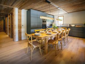 a dining room with a wooden table and chairs at Chalet Frontflip - OVO Network in La Clusaz