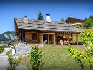 a log cabin with a porch and a large window at Chalet Frontflip - OVO Network in La Clusaz +26 photos
