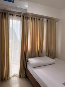 a bedroom with a bed and a window with curtains at Shore Residences TowerA in Manila