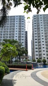 two tall buildings in a city with palm trees at Shore Residences TowerA in Manila