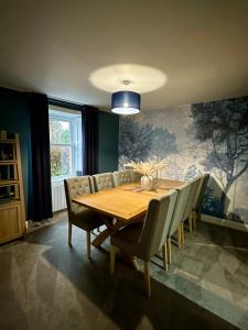 a dining room with a wooden table and chairs at BROOMBANK, Melrose in Gattonside