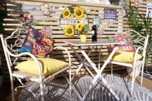 a patio with a table and chairs with sunflowers at The Southbank Torquay by the sea in Torquay