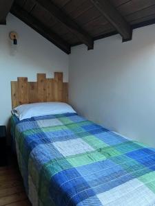 a bedroom with a bed with a blue and green blanket at Relax Luino vista lago Casa LEA in Luino