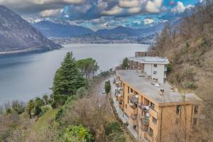 a house on a hill next to a body of water at Lara home in Campione dʼItalia