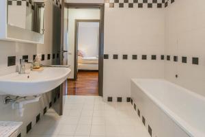 a white bathroom with a sink and a tub at Lara home in Campione dʼItalia
