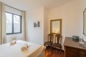 a bedroom with a bed with a mirror and two chairs at Lara home in Campione dʼItalia