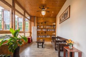 a living room with a ceiling fan and a book shelf at Serenity Inn in Gaotian