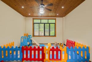 a childs room with a toy fence and a ceiling at Serenity Inn in Gaotian +14 photos
