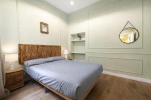 a bedroom with a bed and a mirror on the wall at Apartamentos Málaga centro in Málaga