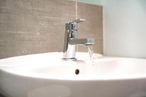 a bathroom sink with water running from a faucet at Folly Lodge in Barnsley +49 photos