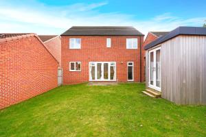 a red brick house with a large yard at Folly Lodge in Barnsley