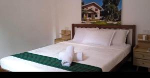 a bedroom with a bed with two rolled towels on it at CASA MIA INN Bed and breakfast in Dauis +106 photos