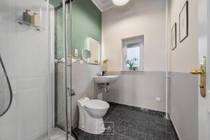 a bathroom with a toilet and a sink and a shower at Art Apartments in Hamburg