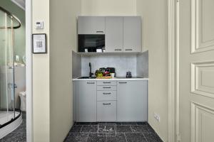 a small kitchen with white cabinets in a hallway at Art Apartments in Hamburg