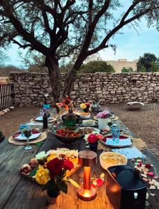 a wooden table with plates of food on it at Idyllic lodge in Essaouira