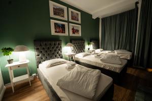 two beds in a room with green walls at Pit Stop Baby in Ploieşti