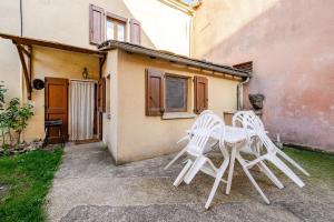 two white chairs and a table in front of a building at Maison avec jardin in Chirac