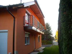 ein orangefarbenes Gebäude mit einem Balkon an der Seite in der Unterkunft Apartman Molnár in Bük