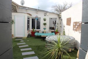a garden with a patio with a bench and a table at Gîte La Tchoupetta,proche Narbonne jaccuzi, jardin, canalplus, netflix in Peyriac-de-Mer