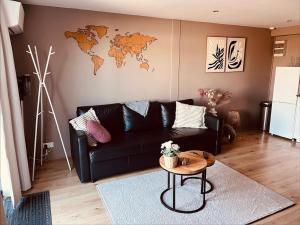 a living room with a black couch and a table at B&B Pardoen in Poortugaal