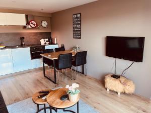 a kitchen and dining room with a table and a tv at B&B Pardoen in Poortugaal