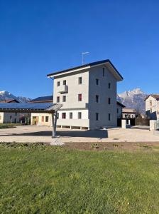 a large white building with mountains in the background at Relais del Borgo in Lentiai