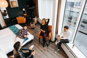 a group of people sitting in a room at The Hague Teleport Hotel - Free Parking in The Hague +26 photos
