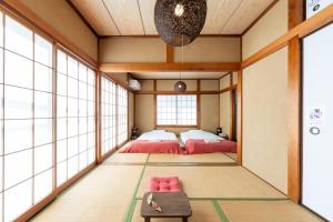 a bedroom with two beds in a room with windows at Coto House Kamakura RoomA in Kamakura